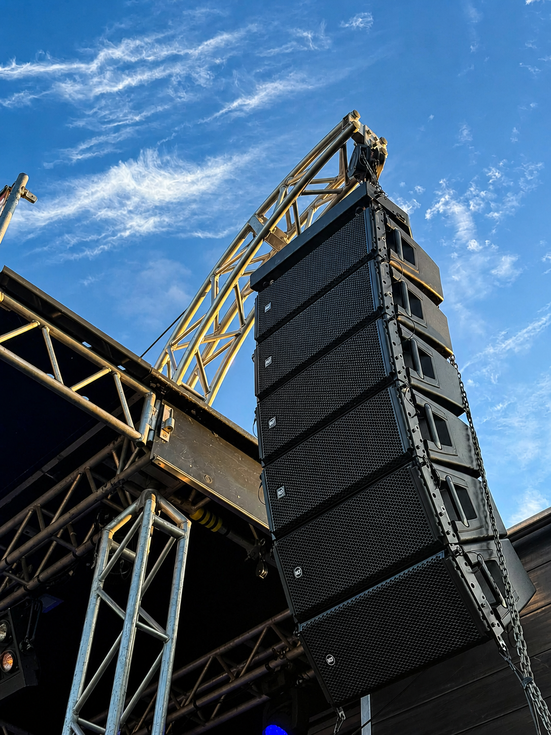 Flown line array sound system against a blue sky